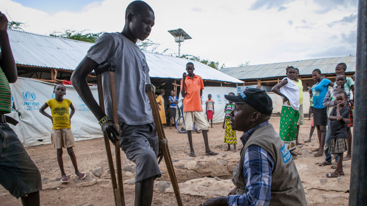 Handicap International rehabilitation team leader Kibet speaks with Simon Ochiti at Kakuma reception center.