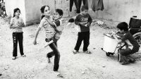 Aya is carried by her sister Iman in a game of hopscotch