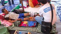 A Handicap International physical therapist assesses an earthquake survivor with a fracture. Nepal
