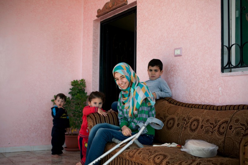 Roqaya sitting outside her house