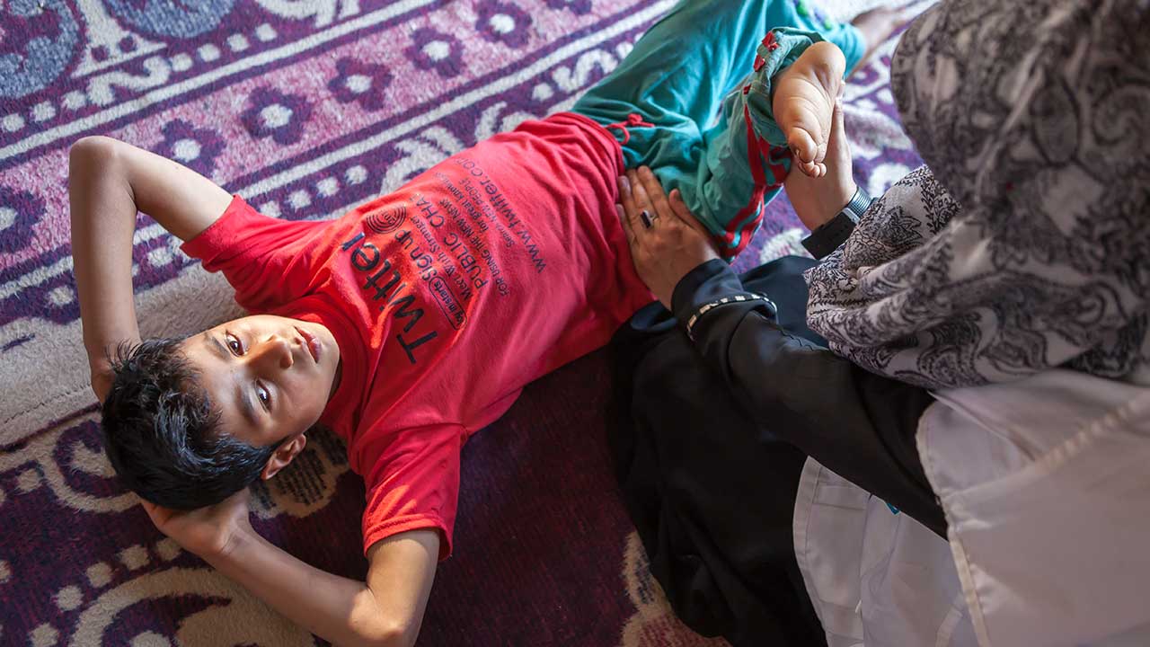 Sahil, 10 years old, doing a rehabilitation session at home in Kashmir.