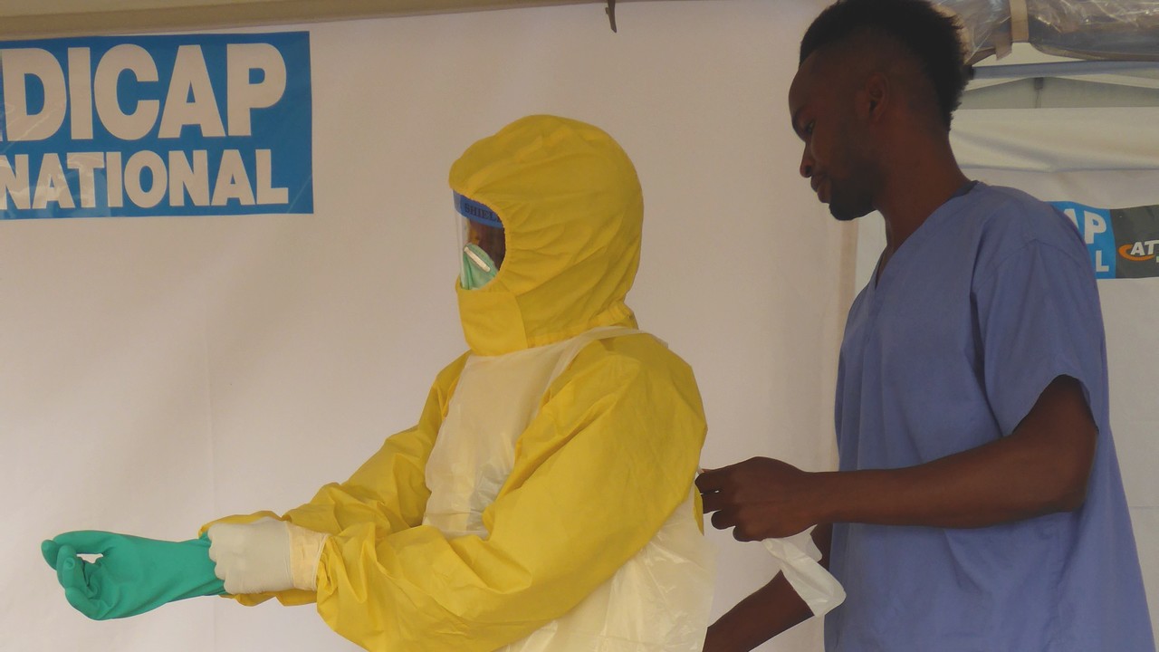 Members of Handicap International's ambulance service team cleans an ambulance with a chlorine solution. Sierra Leone.