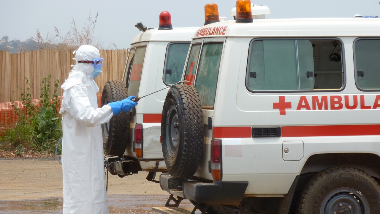 A member of Handicap International's ambulance service team cleans an ambulance with a chlorine solution. Sierra Leone.