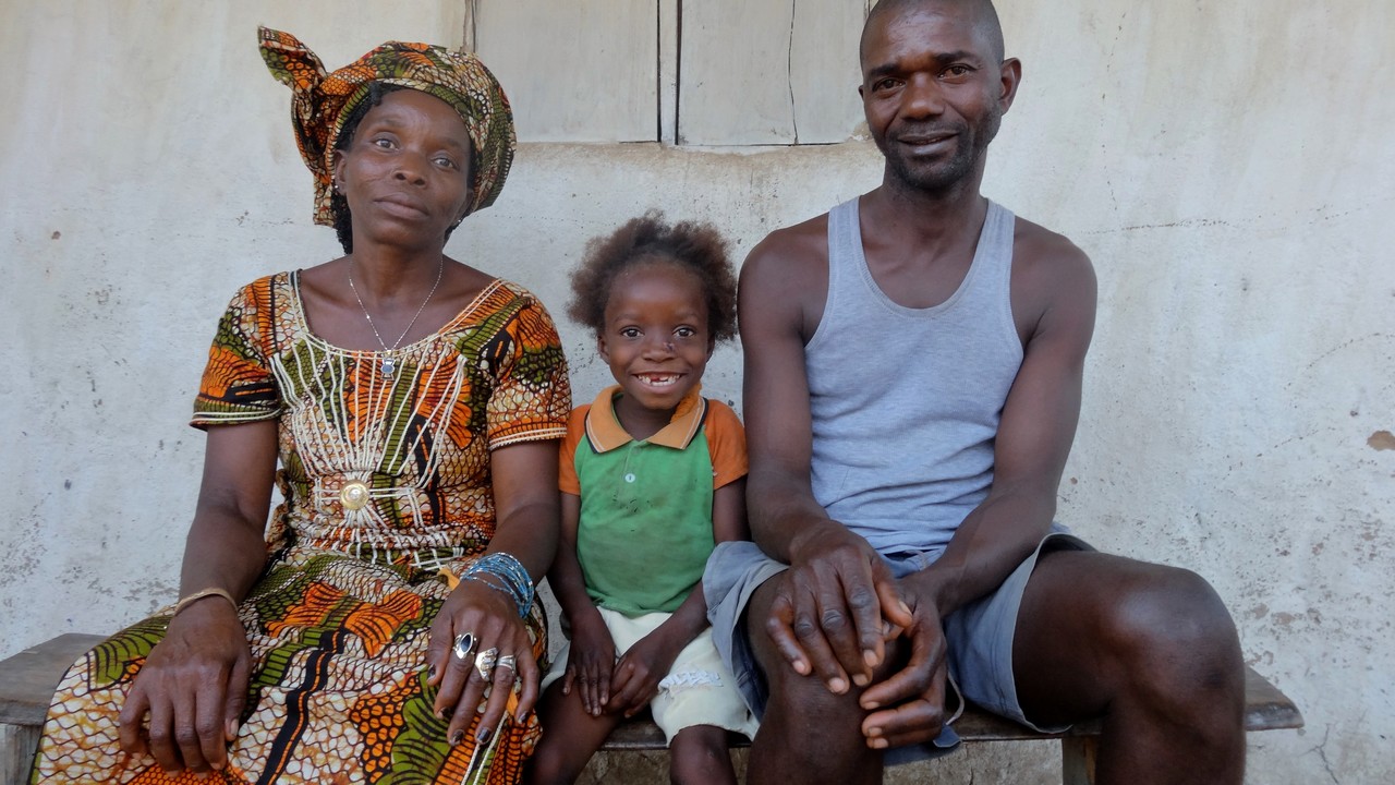 Eight-year-old Fanta, who has cerebral palsy, with her parents. Sierra Leone.