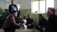 Ali (right) with members of his family meeting one of Handicap International's case workers.