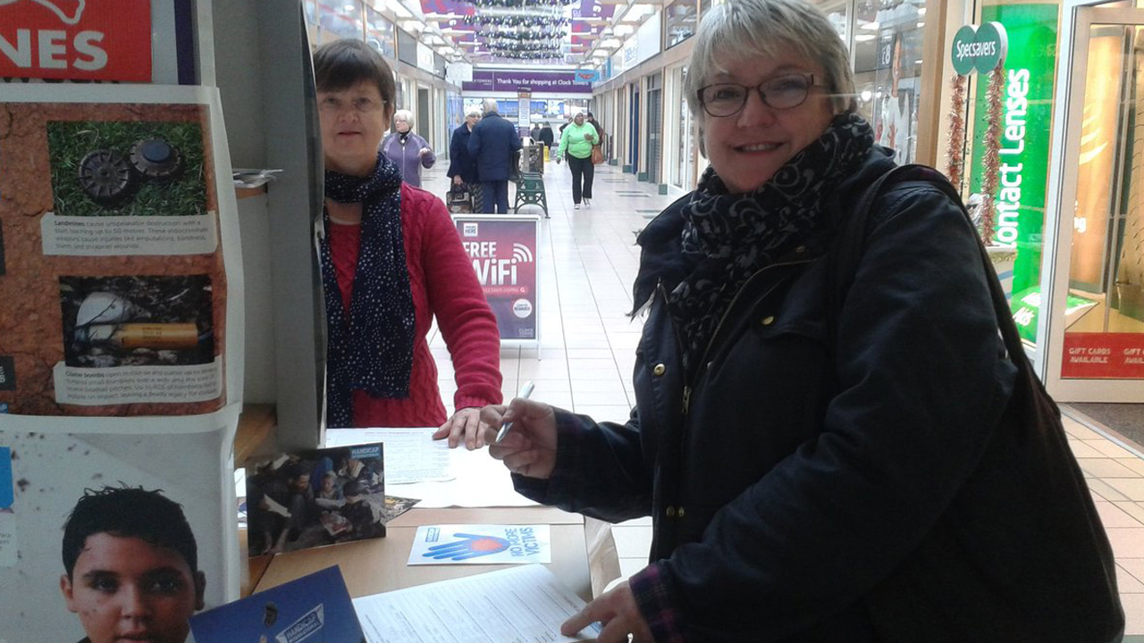 A Christmas shopper in Rugby takes time out to sign the Stop Bombing Civilians petition at a stall organized by Rugby Soroptimists.