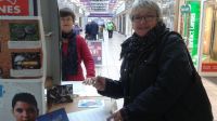 A Christmas shopper in Rugby takes time out to sign the Stop Bombing Civilians petition at a stall organized by Rugby Soroptimists.