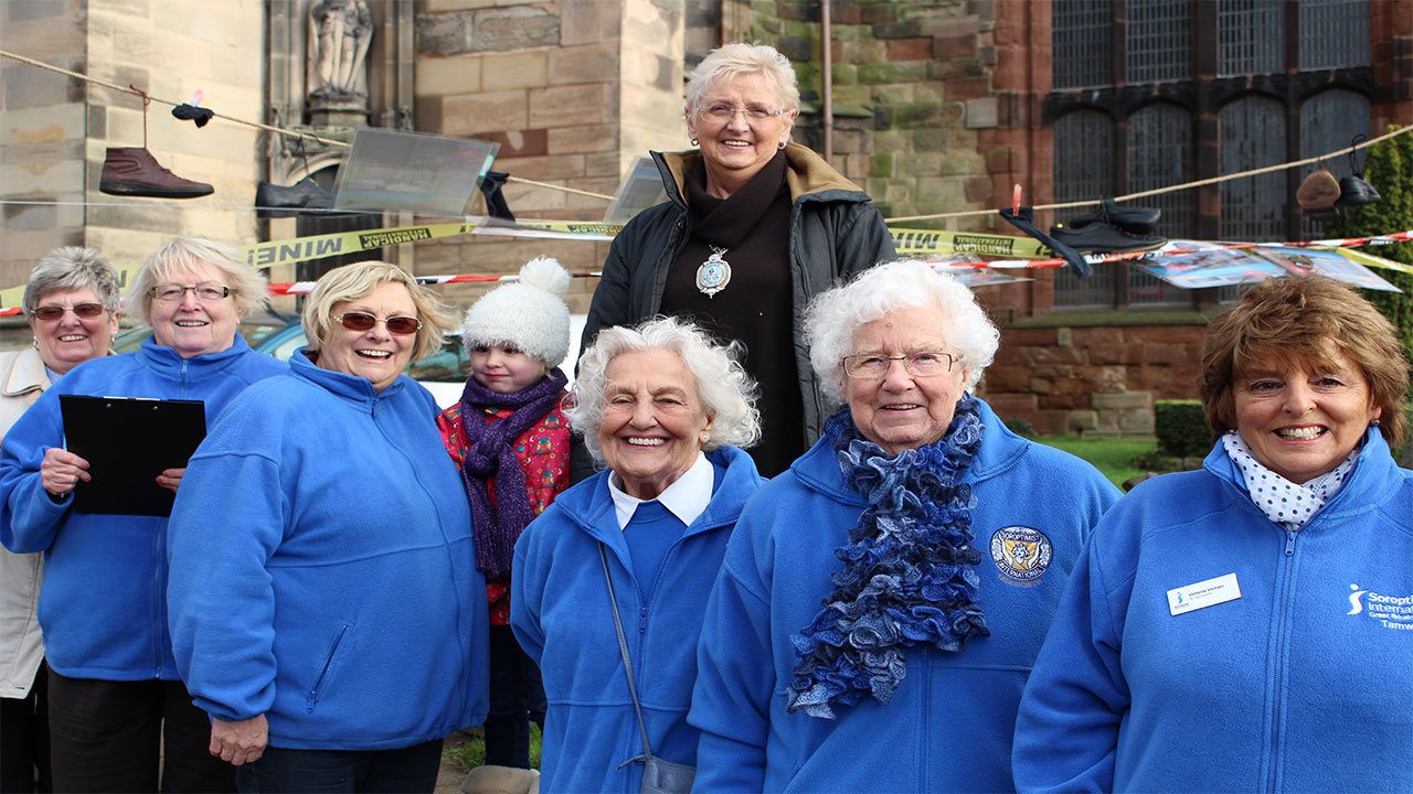 Tamworth Soroptimists outside St. Editha’s Church where they built a Pyramid of Shoes on a windy Friday morning.