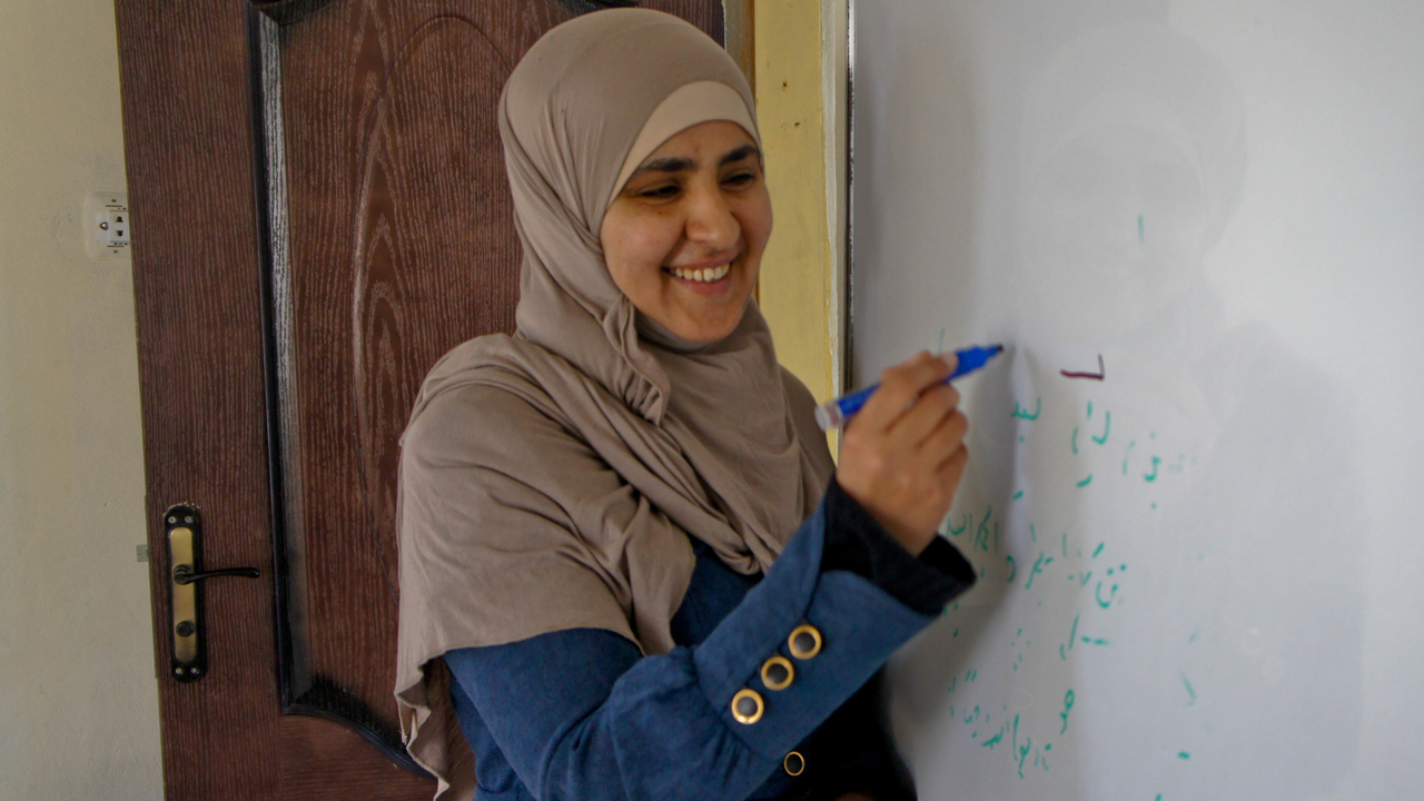  Ashwaq, wirting on a white board in the center that she founded, Jordan.
