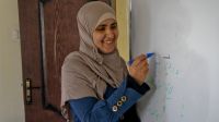  Ashwaq, wirting on a white board in the center that she founded, Jordan.