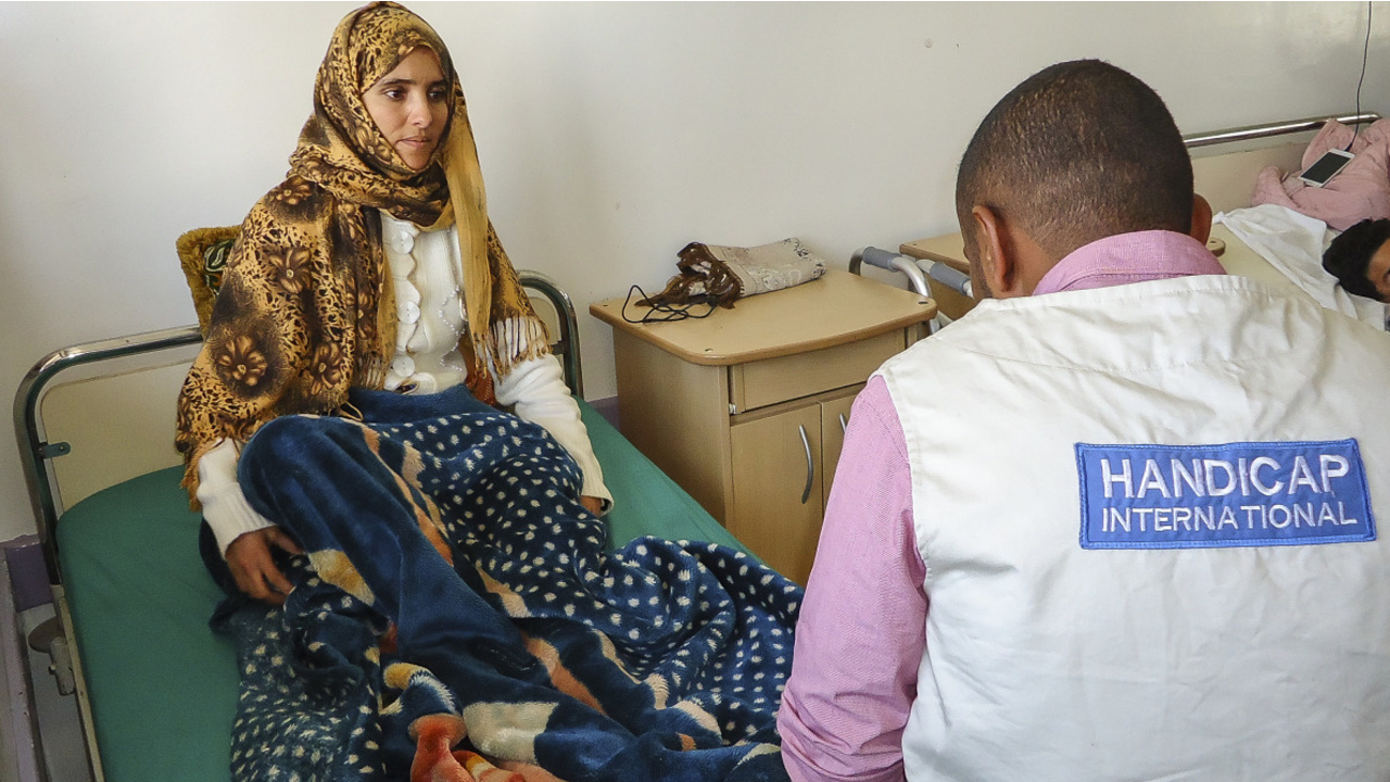 Saeed, a Handicap International physical therapist, with a patient at the Al-Thawra hospital in Sanaa, one of the main hospitals providing care for victims of the conflict. 